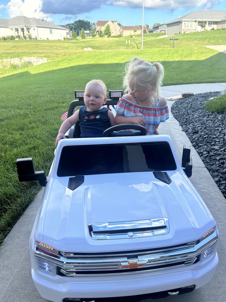 EVie and Hayden in toy car